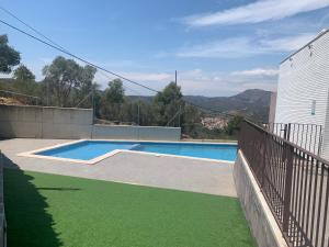 a swimming pool with green grass next to a building at Llançà Apartament Platja Cau del Llop in Llança