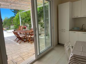 eine Küche und ein Esszimmer mit Glasschiebetüren in der Unterkunft Casa Alfonsa in Villanova di Ostuni