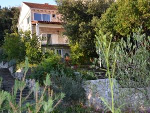 a house with a stone retaining wall and plants at Apartment Karla in Korčula