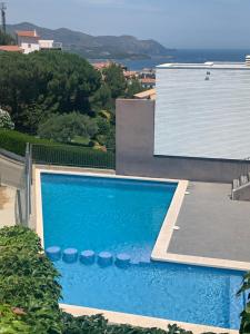 a blue swimming pool in front of a house at Llançà Apartament Platja Cau del Llop in Llança