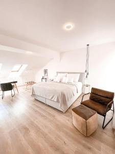 1 dormitorio blanco con 1 cama y 1 silla en Penzion Jakub en Lanškroun