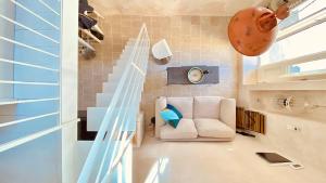 a living room with a white couch and stairs at CASì in Noto +16 photos
