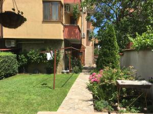 una casa con un patio con flores y una valla en Chervenkov Guest House en Chernomorets