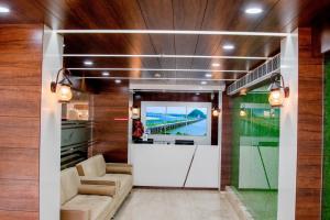 a living room with a tv on a wall at Hotel Namo Residency in Vijayawāda