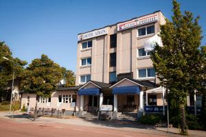 a building with a sign that reads the first inn at Hotel Adlon in Mariehamn