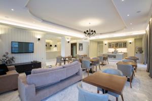 een woonkamer met banken en tafels en een tv bij Lefko Hotel & Apartments in Nydri