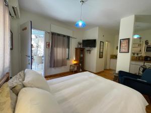 a bedroom with a white bed and a couch at המקום של נטע in Mitzpe Hila