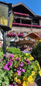 una luz de la calle con flores frente a un edificio en Villa Martha Vintage Hotel-B&B, en Santa Cristina Valgardena