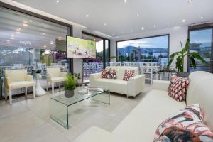 a living room with white furniture and large windows at Patiras Deluxe B&B in Limenaria