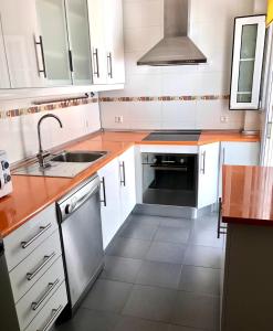 a kitchen with white cabinets and a sink at Mar Azul in Chiclana de la Frontera