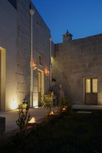 un edificio de piedra con una mesa delante de él por la noche en Casa Frea Dimora Storica, en Martano