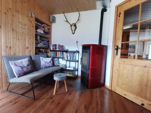 a living room with a couch and a red trash can at Haus Kathan in Kamering