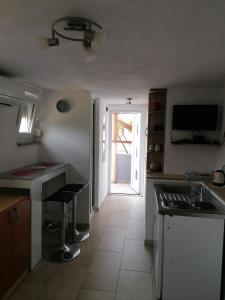 Una cocina con fregadero y puerta a un patio. en Soba Sanja, en Pula