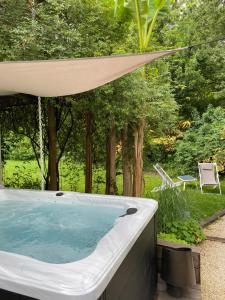 a hot tub in a backyard with a canopy at Chambre d'hôtes au calme avec spa in Nérac