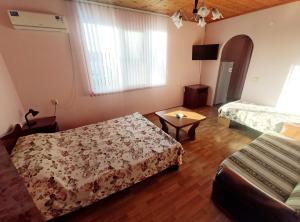 Habitación con 2 camas y mesa. en Guest House on Chernomorskaya Ulitsa, en Anapa