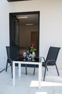 einen schwarz-weißen Tisch mit zwei Stühlen und einer roten Rose in der Unterkunft Lucky Charm in Zadar
