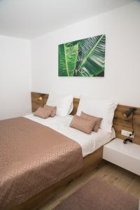 Schlafzimmer mit einem Bett mit weißer und brauner Bettwäsche in der Unterkunft Lucky Charm in Zadar