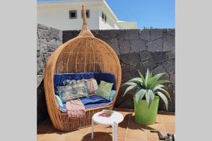 rattanowa huśtawka z poduszkami na patio w obiekcie Villa Lena w mieście Playa Blanca
