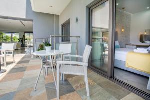 a room with a table and chairs and a bed at Patiras Deluxe B&B in Limenaria
