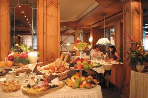 a group of people sitting at tables with fruits and vegetables at Sonnenbichl Hotel am Rotfischbach in Fischen