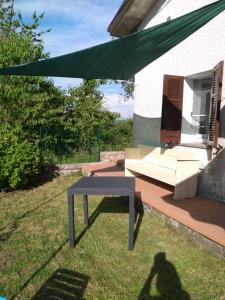 una sombra de una mesa y un sofá en un patio en CASA ELISA (casa della nonna) en Montereggio