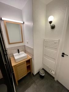 a bathroom with a sink and a mirror at Chaleureux T2 La Tania Courchevel pieds des pistes in Courchevel
