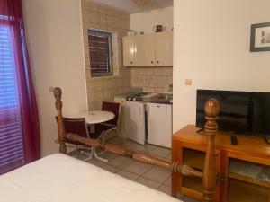 una camera con cucina con tavolo e televisore di Villa Pandza a Seget Vranjica