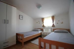 Un dormitorio con dos camas y una ventana. en Pejić Apartments, en Pula