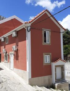 a red and white house with a driveway at Hostel Sertã in Sertã