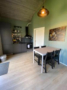 Saltstraumen Hotels Hytter في Knapplund: طاولة وكراسي في غرفة مع مطبخ