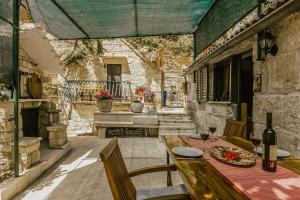 un patio al aire libre con mesa de madera y sillas en Mini stone house en Omiš