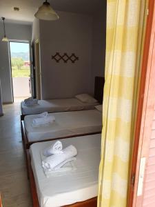 three beds in a room with towels on them at Rivulet Studios in Laganas