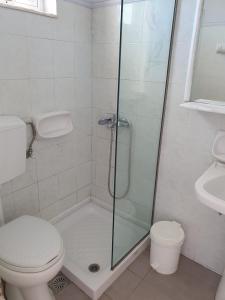 a bathroom with a shower with a toilet and a sink at Rivulet Studios in Laganas +23 photos