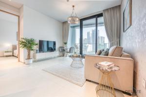 Exquisite 1BR at The Address Residences in JBR by Deluxe Holiday Homes في دبي: غرفة معيشة مع أريكة ونافذة كبيرة