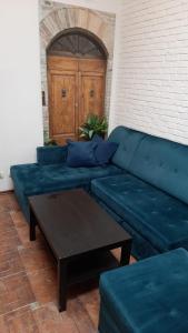 - un canapé bleu avec une table basse dans l'établissement Przytulny loft 5 min od centrum Gdańska, à Gdańsk