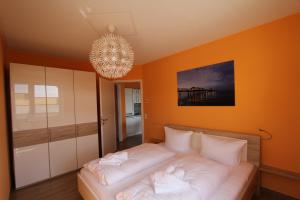 1 dormitorio con 1 cama con lámpara de araña en Die Bleibe, en Ahlbeck