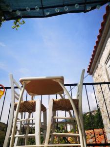 a pair of chairs sitting on a balcony at Mandal Cottage in Samothraki