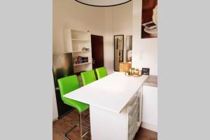 a kitchen with a white counter and green chairs at Apartment in Neudorf Nahe DU Zentrum und Uni/Zoo in Duisburg