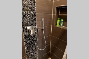 a bathroom with a shower with black tiles at Apartment in Neudorf Nahe DU Zentrum und Uni/Zoo in Duisburg