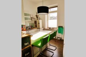 a kitchen with green chairs and a large white table at Apartment in Neudorf Nahe DU Zentrum und Uni/Zoo in Duisburg