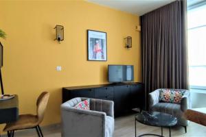 un salon avec deux chaises et une télévision dans l'établissement Appartement T2 Centre-ville Entièrement rénové, à Reims
