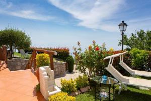 patio con panca, tavolo e alcuni fiori di Il Giardino di Rosa ad Amalfi