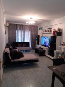 a living room with a couch and a flat screen tv at habitación grande en piso compartido con 2 adultos in Valencia