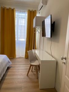 1 dormitorio con escritorio y TV en la pared en FAIROME Guest House, en Roma