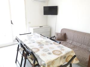 una mesa y sillas en una sala de estar con sofá en Casa vacanze Ginevra, en Fondachello