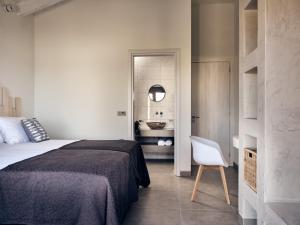 a bedroom with a bed and a white chair at LaLune SeaSide Villa, Zante Zen By ThinkVilla in Kipseli +26 photos