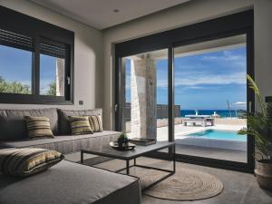 a living room with a couch and a view of the ocean at LaLune SeaSide Villa, Zante Zen By ThinkVilla in Kipseli