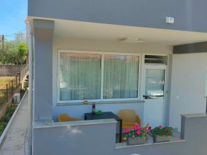 a house with two windows and two chairs and flowers at The Nice Dreams Studio Apartment in Zadar