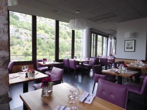 a restaurant with tables and purple chairs and windows at Hotel Beau Site - Rocamadour in Rocamadour