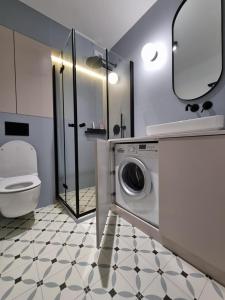a bathroom with a washing machine and a toilet at Apartament na Wydmach Międzywodzie in Międzywodzie